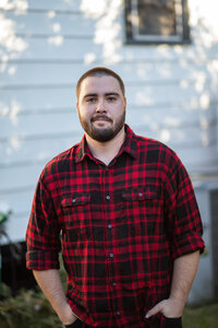 Image of man in plaid shirt, standing proud after overcoming addiction