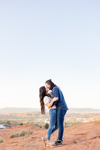 Gorgeous engaged couple share a kiss amongst the red rocks of St George