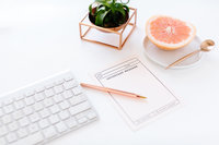 keyboard on desk with fruit and notepad