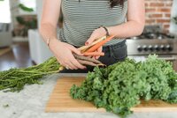 Lifestyle brand image of lady with striped shirt holding carrots