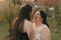 queer couple on their wedding day amongst the apple trees at Smolak Farms. Photo by Rhode Tripper Photography