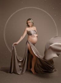 Pregnant mom wrapped in a drape and tossing the material and showing off her baby bump. Outfit is part of JNP's client closet at her Woodstock studio, located outside of Atlanta.