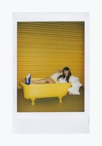 Sasha Fedunchak sitting in a bright yellow bathtub with bright yellow background