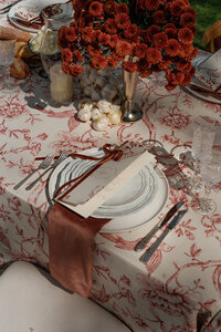 Yellow wedding cake on a yellow table cloth with paper fan open on table
