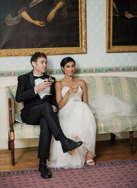 multicultural couple sitting on couch celebrating their wedding day in their estate. person of color.