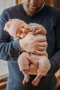 dad holding newborn baby girl in home near eau claire wi