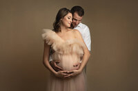 A candid moment between an expecting mother and her husband by Belly to Baby Photography in Charleston, South Carolina.