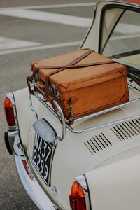 Classic white car with luggage on top — representing adventure, discovery, and stress-free travel planning.