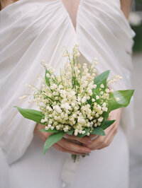 Bride holding Lily of the Valley bouquet for her wedding day