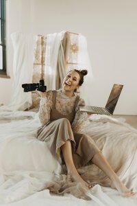 woman holding camera and laptop