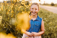 Beautiful girl laughing while playing in flowers  in  Green Bay.