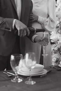 Bride and groom pour a glass of champagne to toast