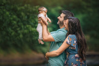 parents hold smiling child during newborn photography session in Langhorne, PA