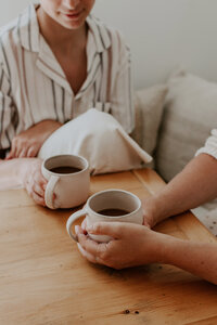 2 woman sitting at a table drinking coffee