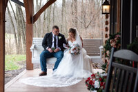 Bride and groom sitting down outside the lodge
