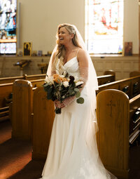 Smiling Bride in Catholic wedding in pews