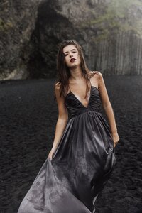 Destination senior pictures in Iceland – girl barefoot in the rain on dramatic black sand beach