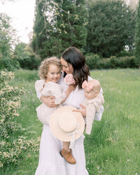 Mother carrying her daughters and giggling through the gardens by Savannah Family photographer Courtney Cronin