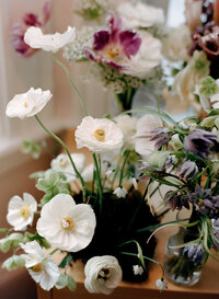 Film photo of an organic wedding floral arrangement with white ranunculus, purple anemones, and wild seasonal blooms — styled and photographed by a film wedding photographer.