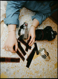 Flat lay of photographer touching film strips and cameras