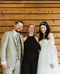 Wedding officiant smiling with newlyweds