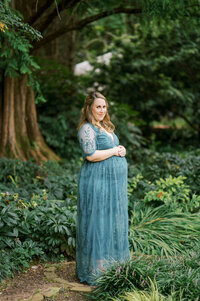 Pregnant woman holds belly during maternity session in Raleigh NC