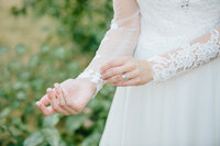 Jackson Hole photographers capture bride adjusting sleeve on wedding dress
