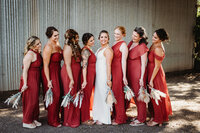 Wedding Photography, bride standing with her bridesmaids all dress in red
