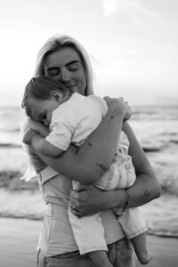 Mama en zoontje tijdens gezinsshoot op het strand