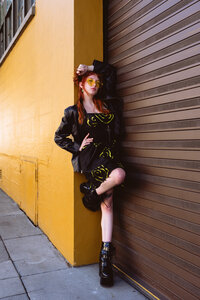 Woman posing confidently against a modern architectural wall in an all-black outfit – branding photo session by Mewphotovideo
