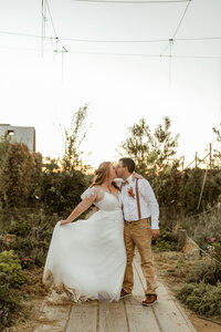 A bride and groom standing close together at [venue name].