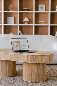 About page of website for newborn sleep coach on laptop sitting on table with bookshelf behind