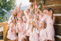 bride, bridesmaids and flower girls pop champagne and cheer at a smoky mountain wedding venue in gatlinburg tennessee