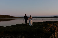 bride and groom embracing in front of rolling hills