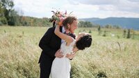 Bride and Groom kissing in field at Wren's Roost Barn in Naples