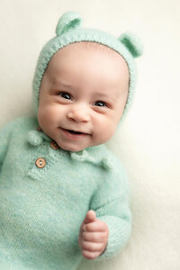 Baby boy smiles during his three month milestone session with Jennifer Brandes Photography.