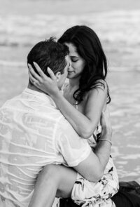 A couple shares an intimate embrace during their engagement session on the beach at Sea Pines, Hilton Head. A romantic and timeless black-and-white coastal moment.