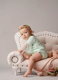 Beautiful little girl sitting in a small couch