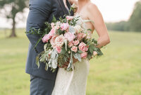 picture of wedding  pink and white bouquet while the bride and groom hold it in summerfield nc