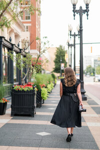 woman walking down the sidewalk in a city