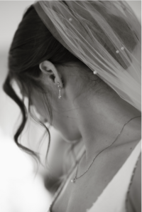 bride getting ready for wedding wearing pearl veil in black and white