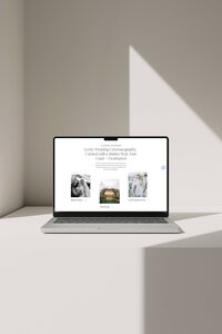 An open laptop sitting on a beige surface with a refraction of light behind