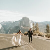 man and woman holding hands while walking down street