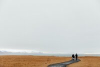 Bride and groom walking hand in hand on a path through nordic landscape – adventure elopement photographer in the West