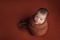 newborn boy in potato pose during newborn session in tampa, florida