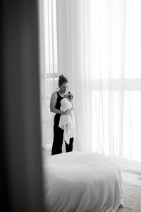 Lucy jane holding a newborn baby and soothing it by rocking it during a newborn photoshoot in her christchurch studio