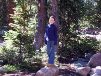 Young girl standing on rocks in the wilderness while camping.