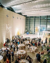 Wedding guests dance underneath ambient market lighting