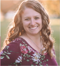 Copywriting business coaching client, Vicky of Molla Content & Design smiling with the sun setting behind her.