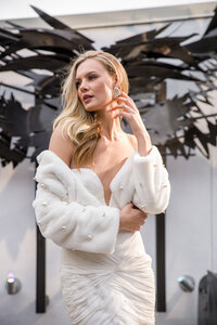 Commercial image of a model in white in front of angel wings